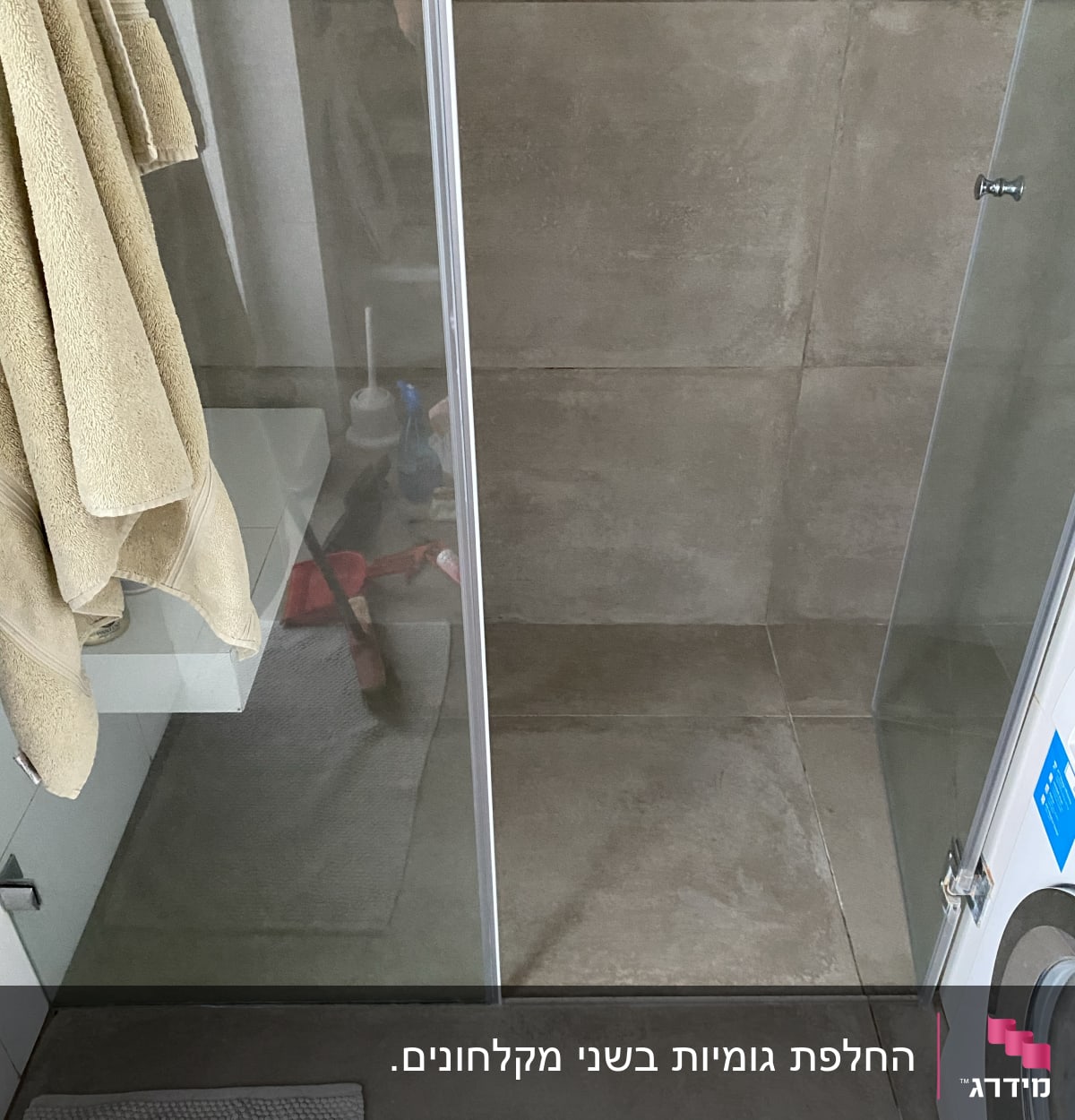 מקלחון זכוכית עם מגבות תלויים בצד